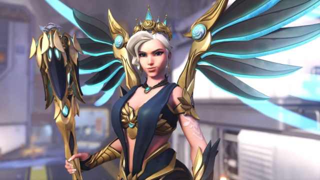 Изображение нового скина Rose Majesty Mercy в Overwatch 2, который украшает ее темно-синим платьем и золотыми вставками.